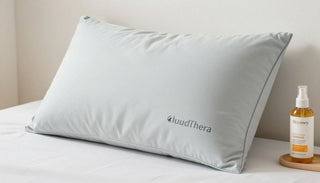 A light blue pillow with the CloudThera logo sits on a white bed.