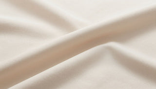A close-up of Dreamey CloudThera™ sheets in a soft, neutral color, showing the smooth texture of the fabric.
