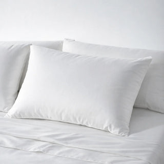 Clean white eucalyptus lyocell pillowcases on a made bed, the surface skin rests against for 8 hours a night