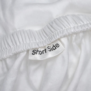 Close-up of a eucalyptus lyocell fitted sheet edge and sewn-in fabric tag, the only place a bedding fiber is named