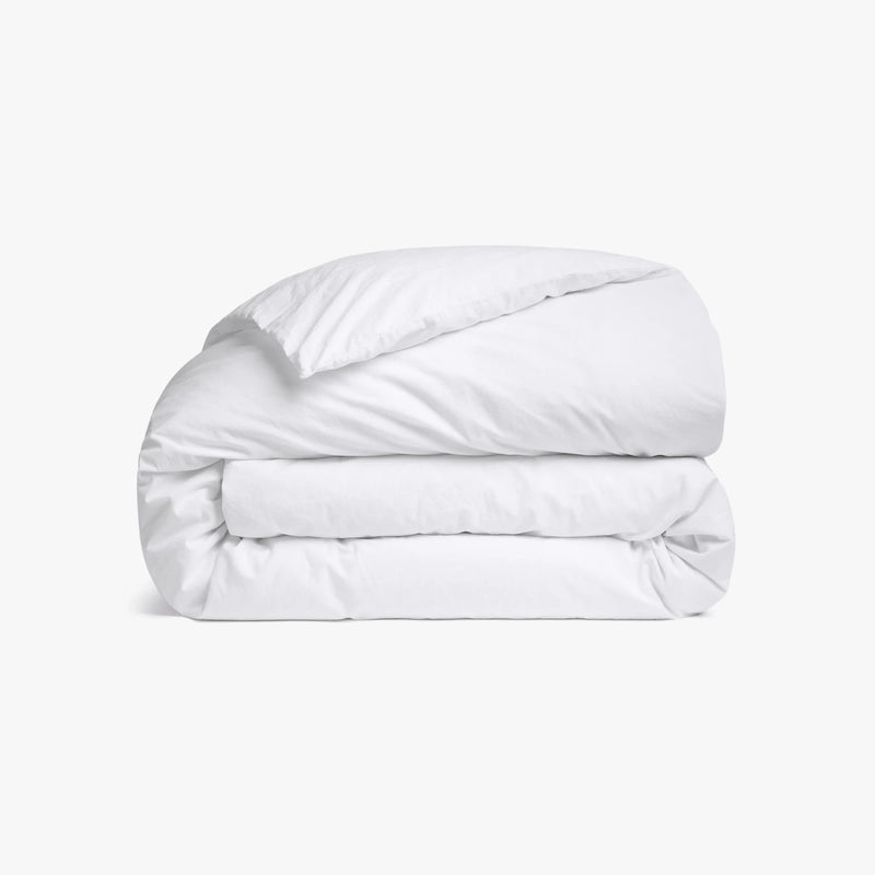 Folded white comforter on a white background