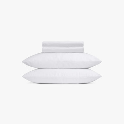 Set of white pillows and bed sheets on a white background