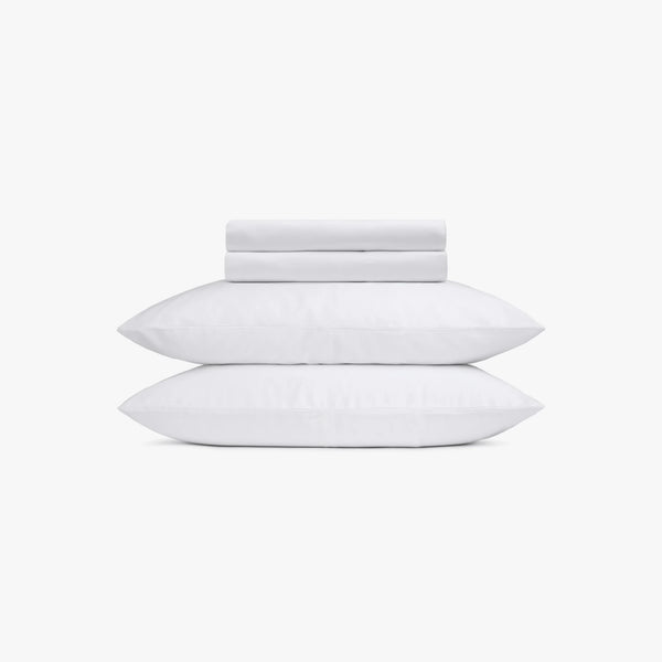 Set of white pillows and bed sheets on a white background