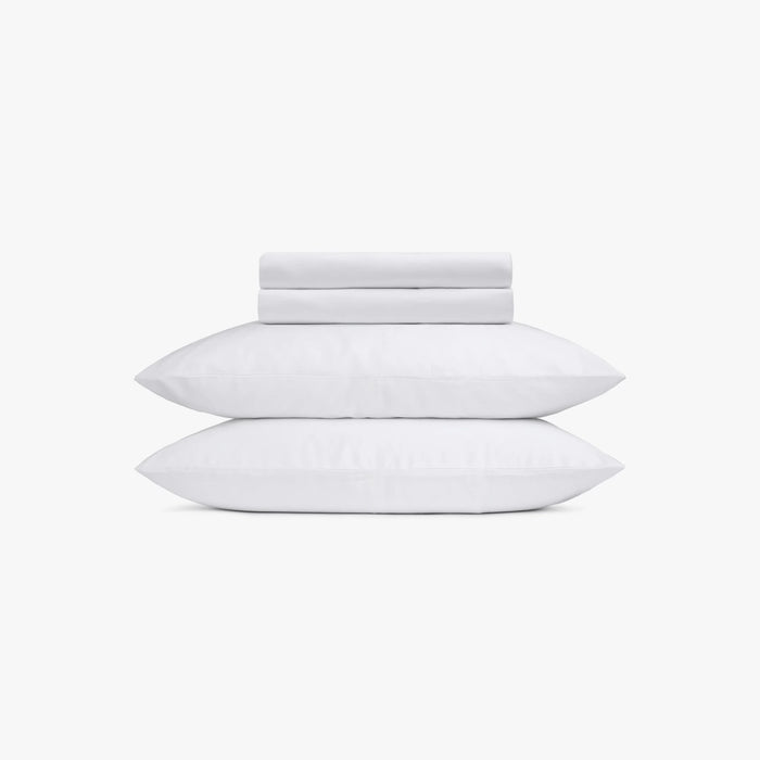 Set of white pillows and bed sheets on a white background