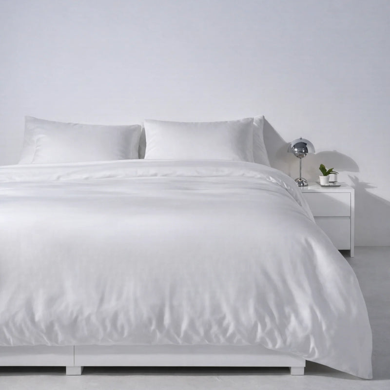 Bed made with the Buttercream eucalyptus Complete Sleep set beside a nightstand and lamp